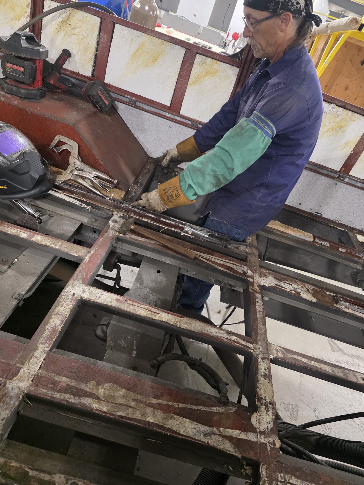 Technician fitting a new floor panel during a factory refurbishment