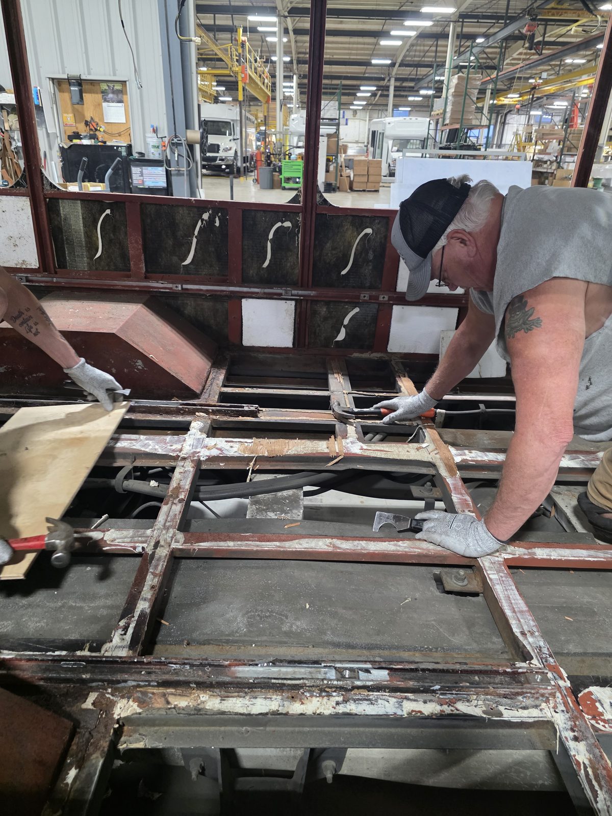 Technician cutting rusted floor structure out of a shuttle bus body